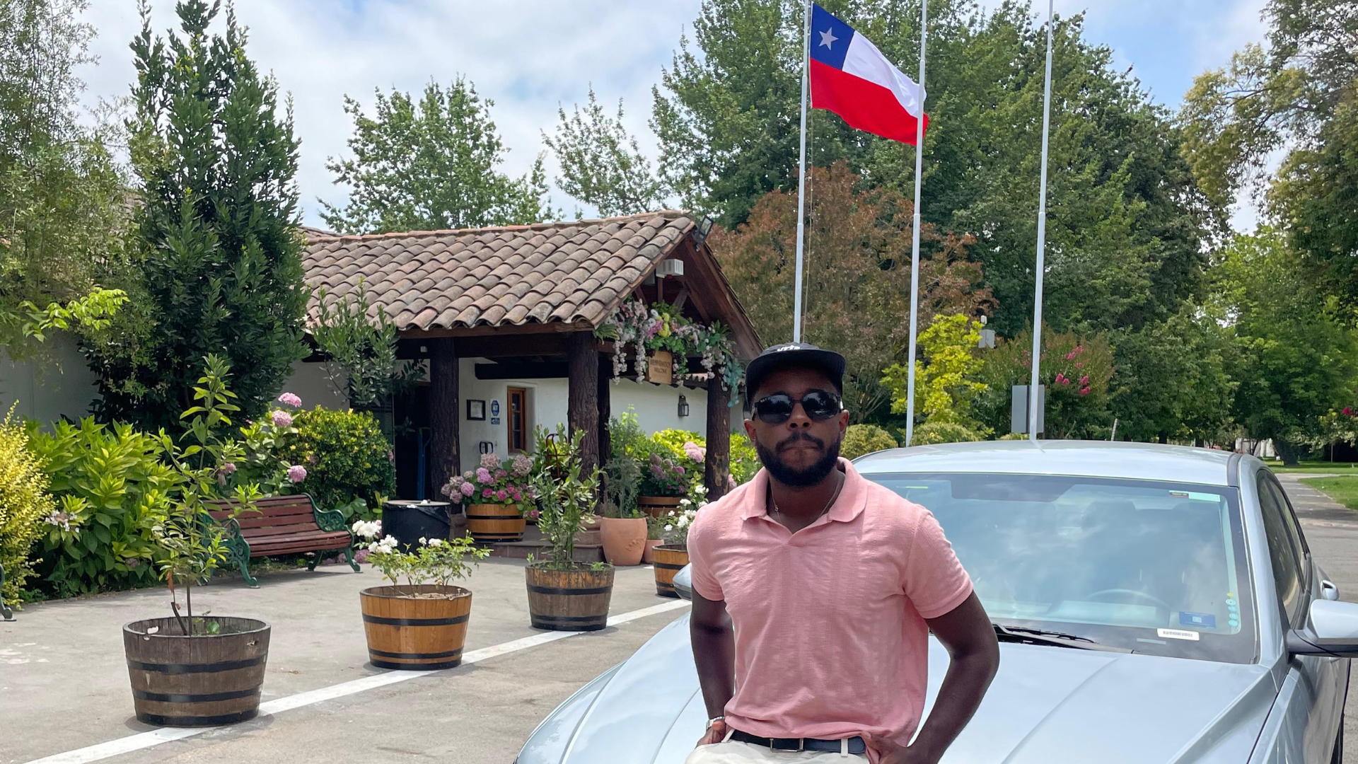 Euler ao lado do carro, bandeira do Chile ao fundo